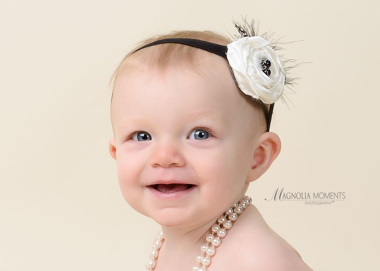 Adorable closeup of a one year old birthday girl taken in her 1st birthday photography session by Evan Pollock of Magnolia Moments Photography who has a photography studio near me