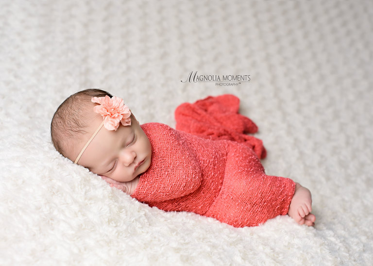 Newborn baby girl wrapped in pink on cream blanket during her newborn photography session by Evan Pollock of Magnolia Moments Photography a photography studio near me - Collegeville newborn photography
