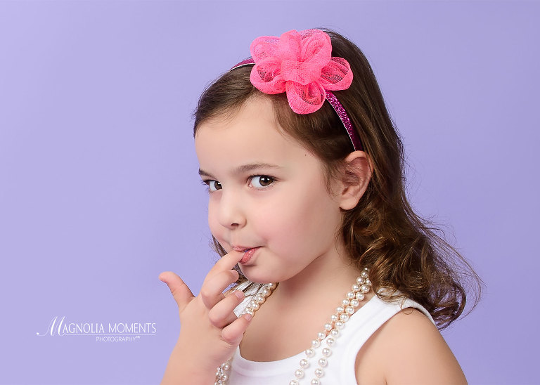 Close up of birthday girl tasting icing on her finger during her birthday photography session by Evan Pollock of Magnolia Moments Photography one of the professional photography studios near me. Collegeville child photographer.