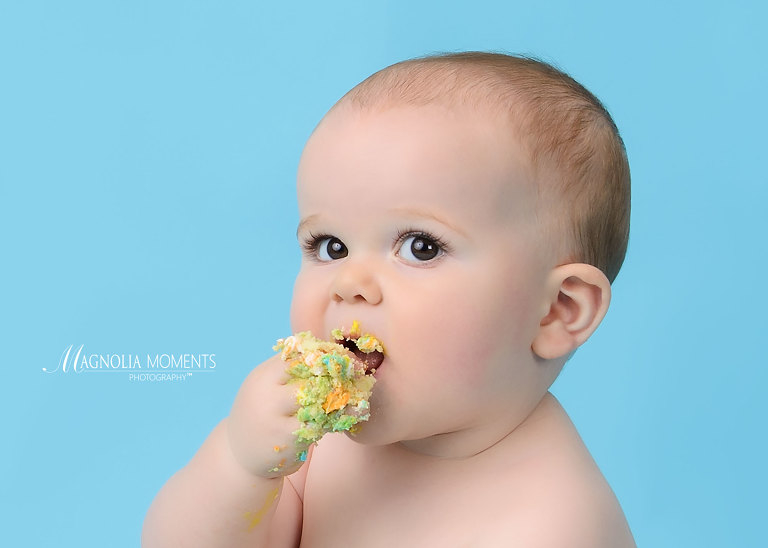Close-up of baby boy eating cake during his 1st birthday cake smash portrait session by Evan Pollock of Magnolia Moments Photography one of the photographers near me. Philadelphia baby photographer