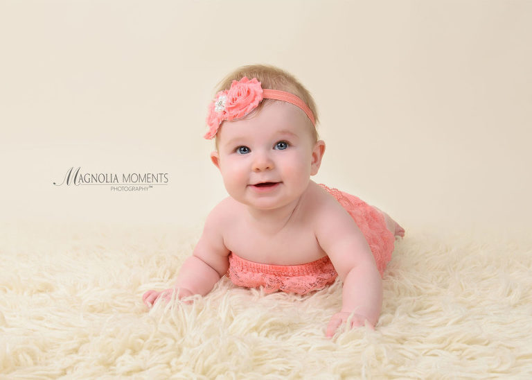 Sweet baby girl in pink on cream fur during her baby photography session by Evan Pollock of Magnolia Moments Photography who does baby photography near me.Mont Clare baby photographer.